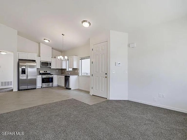 14309 Seth Payne Dr, El Paso, TX 79928 - kitchen with stainless steel appliances, a chandelier, white cabinetry, pendant lighting, and vaulted ceiling