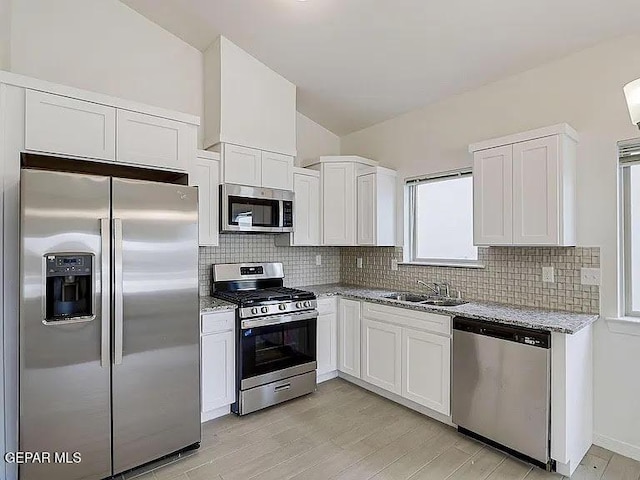 14309 Seth Payne Dr, El Paso, TX 79928 - kitchen featuring stainless steel appliances, backsplash, lofted ceiling, light stone counters, and white cabinets