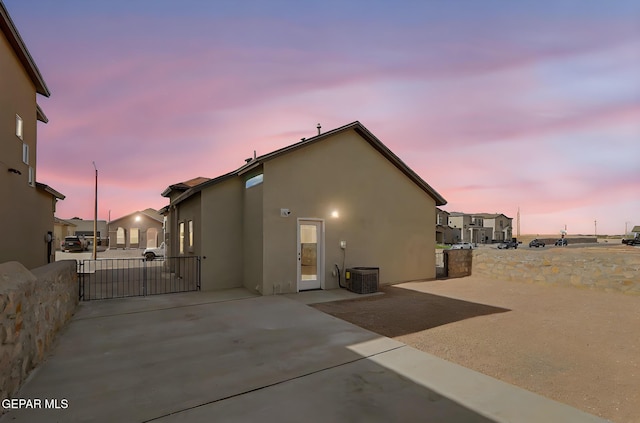 14309 Seth Payne Dr, El Paso, TX 79928 - back of property at dusk with a patio area, stucco siding, a gate, and a residential view
