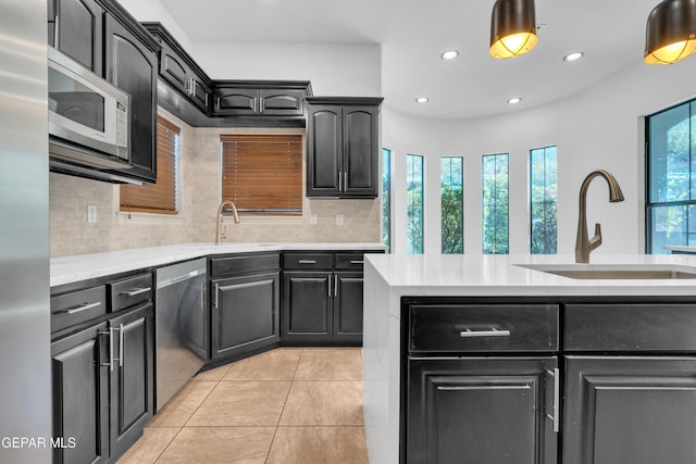 5833 Sundale Rd, El Paso, TX 79912 - kitchen featuring appliances with stainless steel finishes, light tile patterned flooring, light countertops, decorative backsplash, and recessed lighting