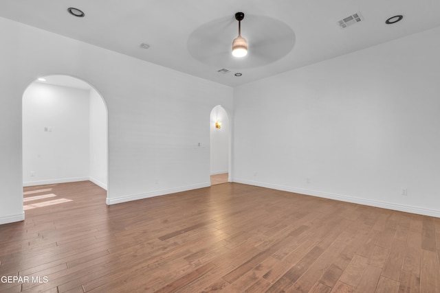 5833 Sundale Rd, El Paso, TX 79912 - unfurnished room featuring arched walkways, a ceiling fan, and hardwood / wood-style floors