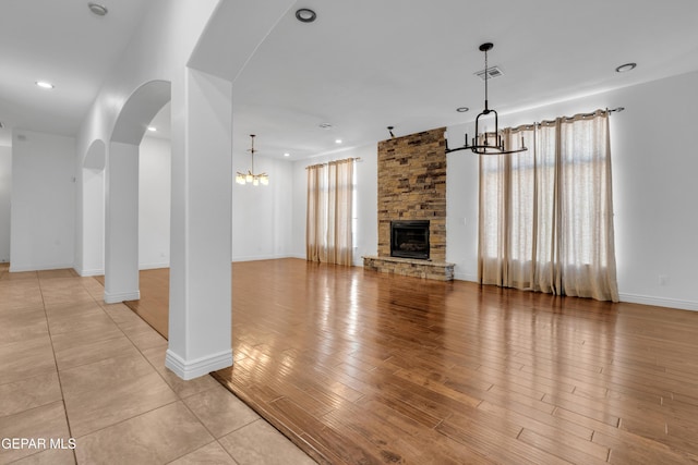 5833 Sundale Rd, El Paso, TX 79912 - unfurnished living room featuring a chandelier, arched walkways, a fireplace, recessed lighting, and light wood-style flooring