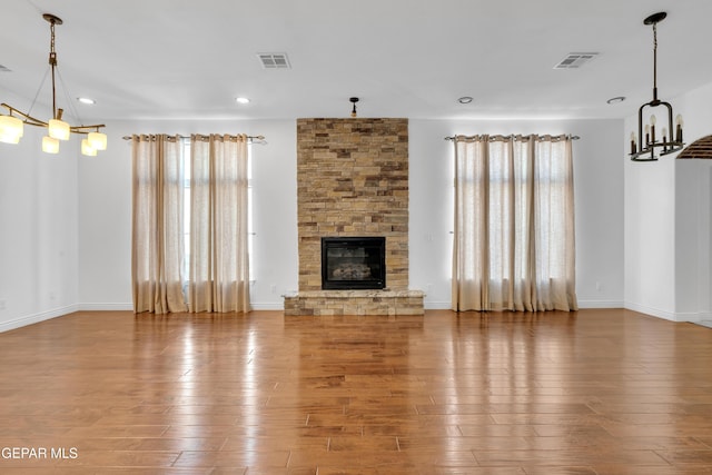 5833 Sundale Rd, El Paso, TX 79912 - unfurnished living room featuring a chandelier, hardwood / wood-style floors, a stone fireplace, and recessed lighting
