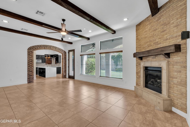 5833 Sundale Rd, El Paso, TX 79912 - unfurnished living room with a large fireplace, beam ceiling, light tile patterned floors, a ceiling fan, and recessed lighting