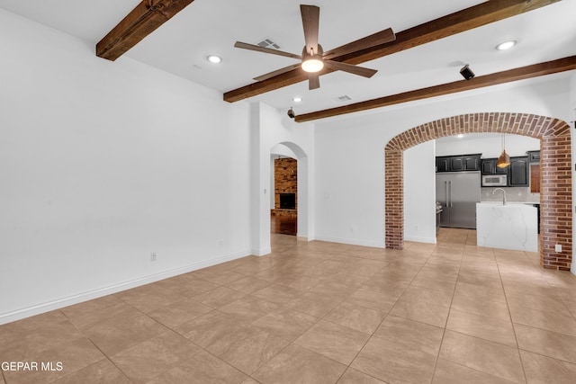 5833 Sundale Rd, El Paso, TX 79912 - unfurnished living room featuring arched walkways, beam ceiling, ceiling fan, light tile patterned floors, and recessed lighting