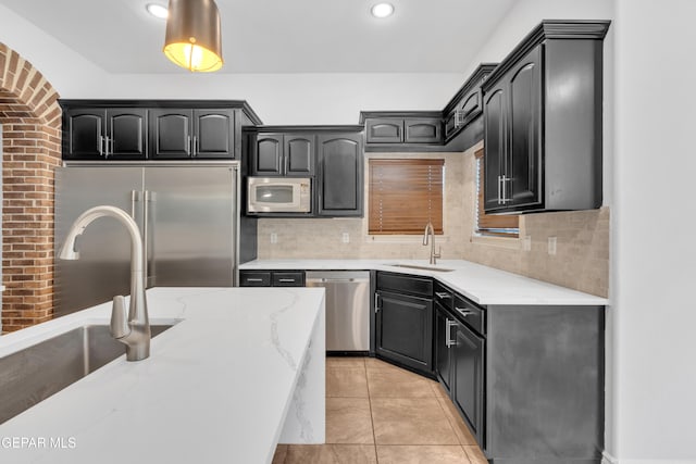 5833 Sundale Rd, El Paso, TX 79912 - kitchen with stainless steel appliances, light stone counters, decorative backsplash, recessed lighting, and light tile patterned floors