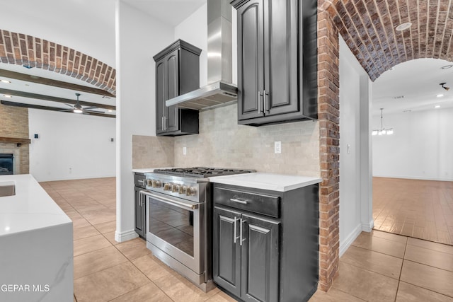 5833 Sundale Rd, El Paso, TX 79912 - kitchen with stainless steel range, wall chimney range hood, open floor plan, a ceiling fan, and light tile patterned floors