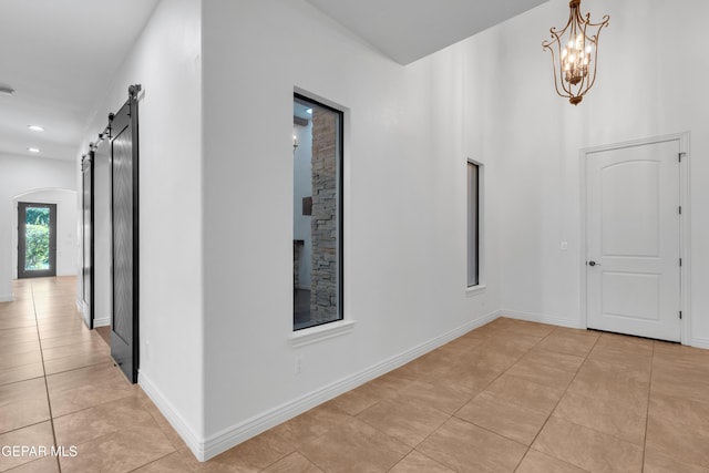5833 Sundale Rd, El Paso, TX 79912 - hallway with light tile patterned floors, a barn door, a chandelier, and arched walkways