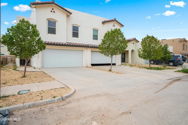 801 Hc Gilbert Minjares Dr Unit A, Socorro, TX 79927 - mediterranean / spanish house featuring a tiled roof, a garage, stucco siding, and driveway