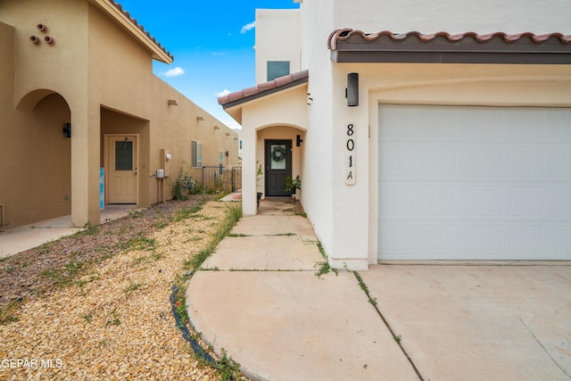 801 Hc Gilbert Minjares Dr Unit A, Socorro, TX 79927 - property entrance featuring stucco siding, a garage, a tiled roof, and driveway
