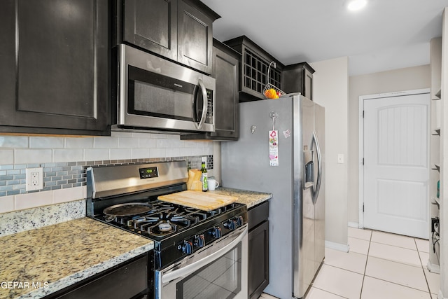 801 Hc Gilbert Minjares Dr Unit A, Socorro, TX 79927 - kitchen with appliances with stainless steel finishes, decorative backsplash, light tile patterned floors, light stone counters, and dark cabinets