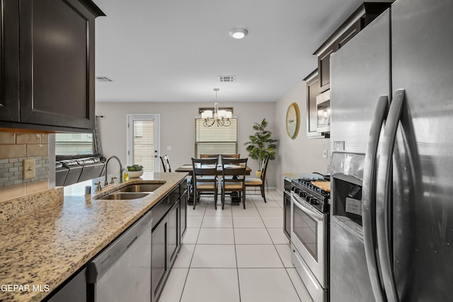 801 Hc Gilbert Minjares Dr Unit A, Socorro, TX 79927 - kitchen featuring stainless steel appliances, light stone countertops, light tile patterned floors, a chandelier, and decorative light fixtures