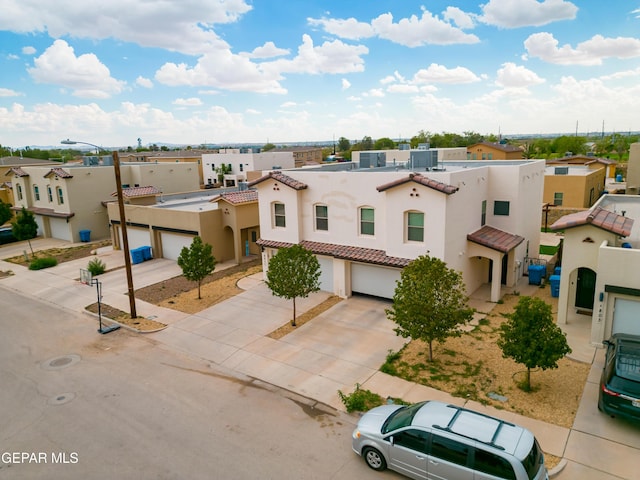 801 Hc Gilbert Minjares Dr Unit A, Socorro, TX 79927 - mediterranean / spanish-style home with concrete driveway, a tile roof, stucco siding, an attached garage, and a residential view