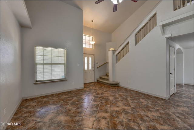 3517 Tierra Bahia Dr, El Paso, TX 79938 - entryway with high vaulted ceiling, ceiling fan, arched walkways, stairway, and stone finish flooring