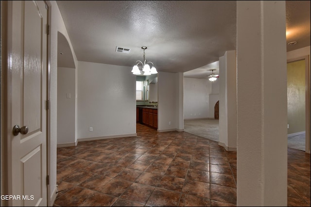3517 Tierra Bahia Dr, El Paso, TX 79938 - spare room with arched walkways, ceiling fan, a textured ceiling, and a chandelier