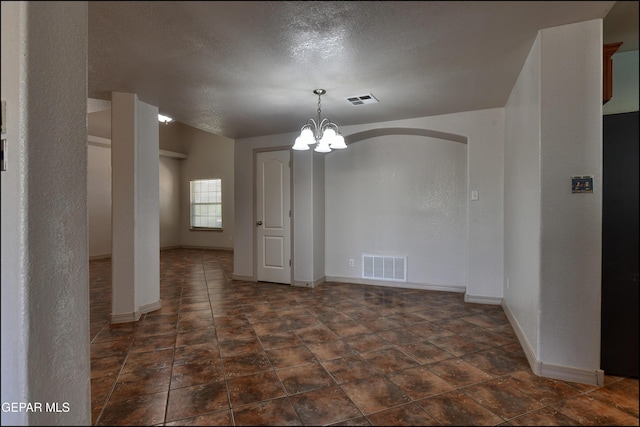 3517 Tierra Bahia Dr, El Paso, TX 79938 - empty room featuring a chandelier, arched walkways, and a textured ceiling