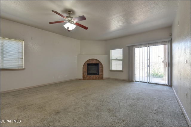 3517 Tierra Bahia Dr, El Paso, TX 79938 - unfurnished living room with carpet floors, a tile fireplace, ceiling fan, and a textured ceiling