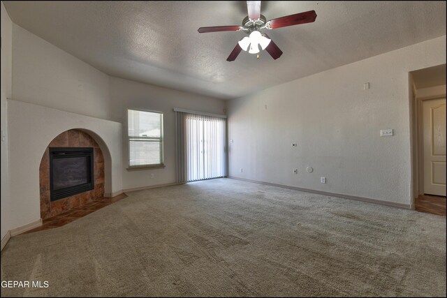 3517 Tierra Bahia Dr, El Paso, TX 79938 - unfurnished living room featuring carpet floors, a tiled fireplace, a textured ceiling, and ceiling fan