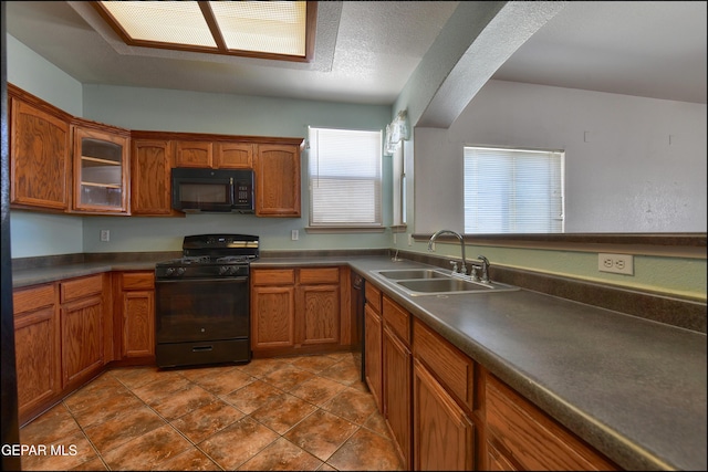 3517 Tierra Bahia Dr, El Paso, TX 79938 - kitchen with black appliances, brown cabinetry, glass insert cabinets, dark countertops, and dark tile patterned flooring