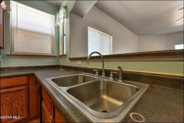 3517 Tierra Bahia Dr, El Paso, TX 79938 - kitchen with dark countertops, brown cabinetry, and a textured wall