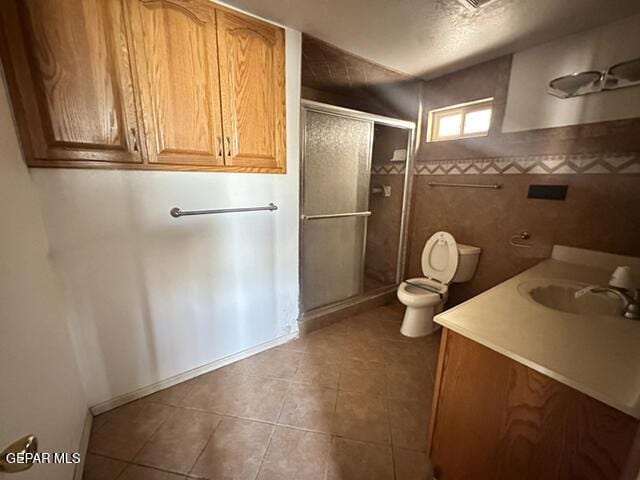209 Durrill Rd, El Paso, TX 79915 - full bathroom with a stall shower, vanity, tile patterned flooring, tile walls, and a textured ceiling