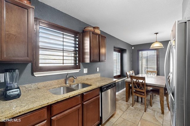 4640 Beacham St, El Paso, TX 79938 - kitchen featuring stainless steel appliances, decorative light fixtures, light stone countertops, light tile patterned floors, and a textured wall