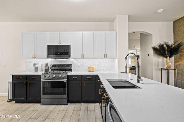 12334 Westbury, El Paso, TX 79928 - kitchen featuring stainless steel appliances, arched walkways, white cabinets, and light wood-style floors