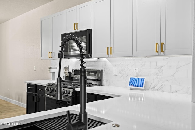 12334 Westbury, El Paso, TX 79928 - kitchen featuring stainless steel gas range oven, light countertops, tasteful backsplash, dark cabinetry, and white cabinetry