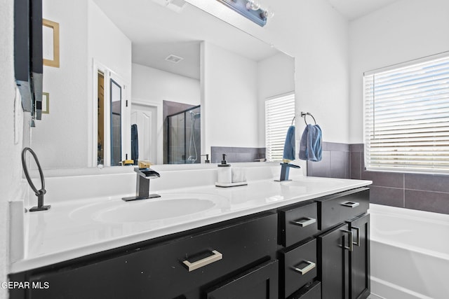12334 Westbury, El Paso, TX 79928 - bathroom featuring double vanity, a shower stall, and a garden tub
