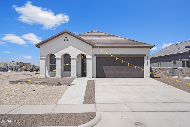 224 Penbridge Pl, El Paso, TX 79928 - view of front of home with a tile roof, a garage, concrete driveway, and stucco siding