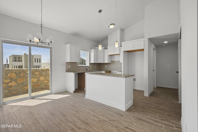 224 Penbridge Pl, El Paso, TX 79928 - kitchen featuring tasteful backsplash, a chandelier, white cabinetry, light wood-type flooring, and a center island
