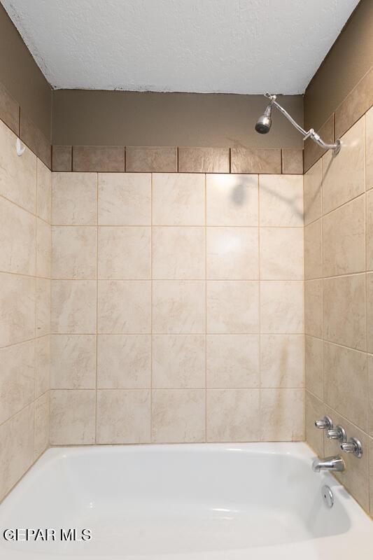 1615 Opossum Cir, Horizon City, TX 79928 - full bath featuring a textured ceiling and bathing tub / shower combination