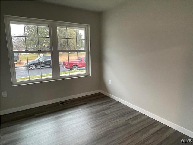 unfurnished room with dark wood-type flooring