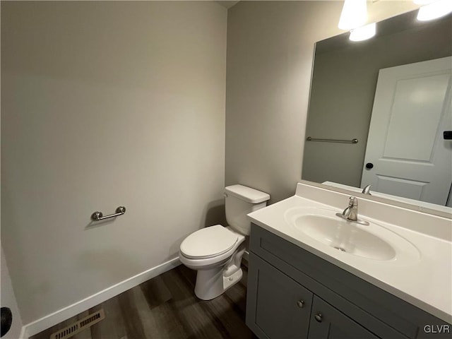 bathroom with hardwood / wood-style floors, vanity, and toilet