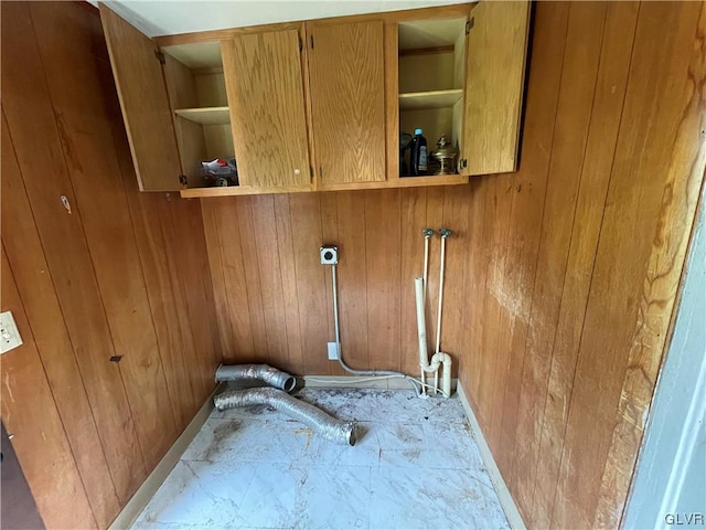 washroom with cabinets and wooden walls