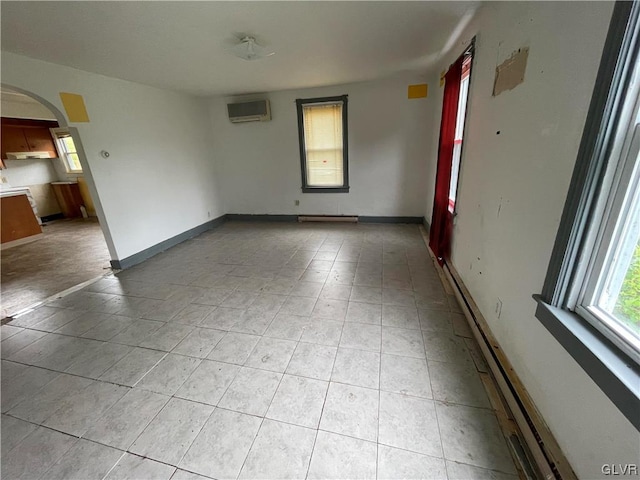 unfurnished room featuring baseboard heating and a wall mounted AC