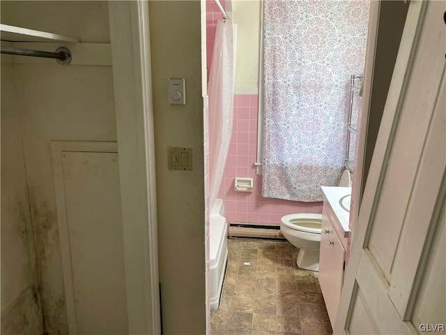 bathroom featuring vanity, tile walls, toilet, and a baseboard heating unit