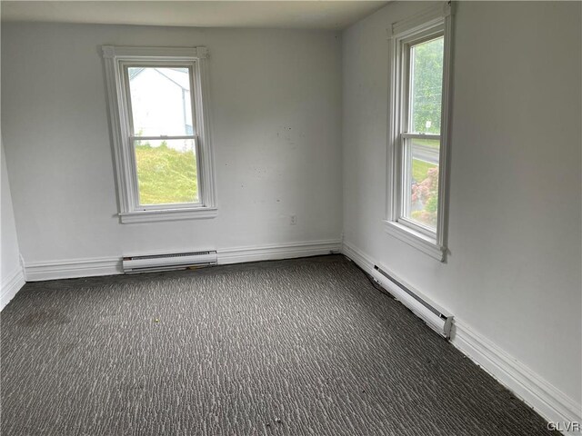 carpeted spare room with a baseboard radiator and plenty of natural light