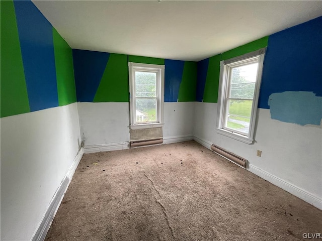 carpeted empty room with a baseboard heating unit