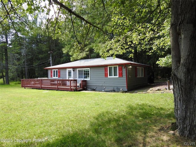 view of front of home featuring a wooden deck and a front yard