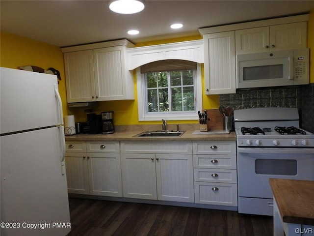 kitchen with white appliances, sink, white cabinets, and dark hardwood / wood-style flooring