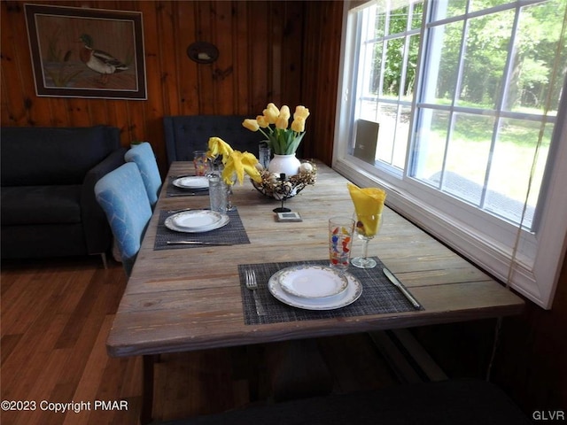 dining room with wood-type flooring and wood walls