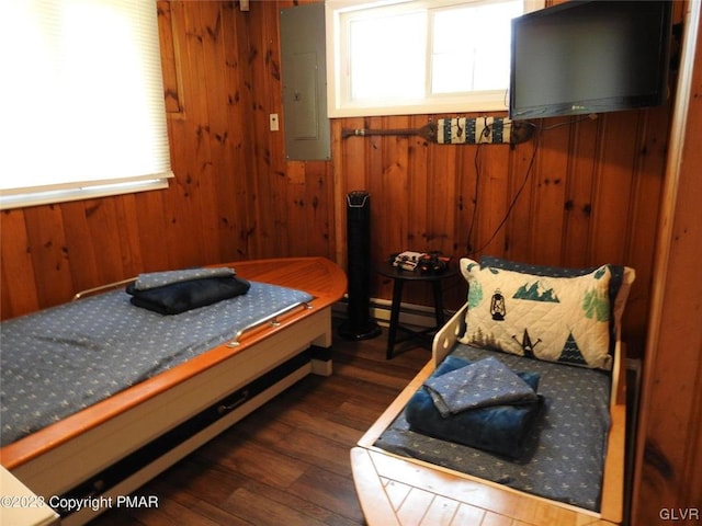 bedroom featuring dark hardwood / wood-style floors, wood walls, and electric panel