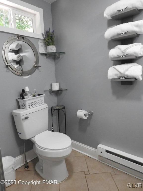 bathroom featuring toilet, a baseboard heating unit, and tile patterned floors