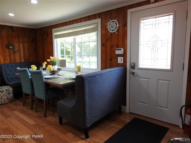 foyer entrance featuring crown molding, wood-type flooring, and wooden walls