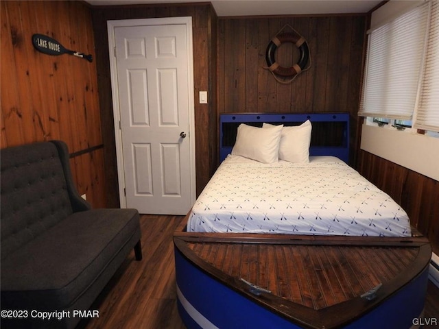 bedroom featuring wooden walls and dark wood-type flooring