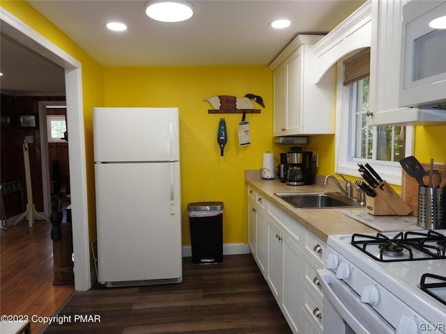 kitchen with white appliances, sink, dark wood-type flooring, and white cabinets