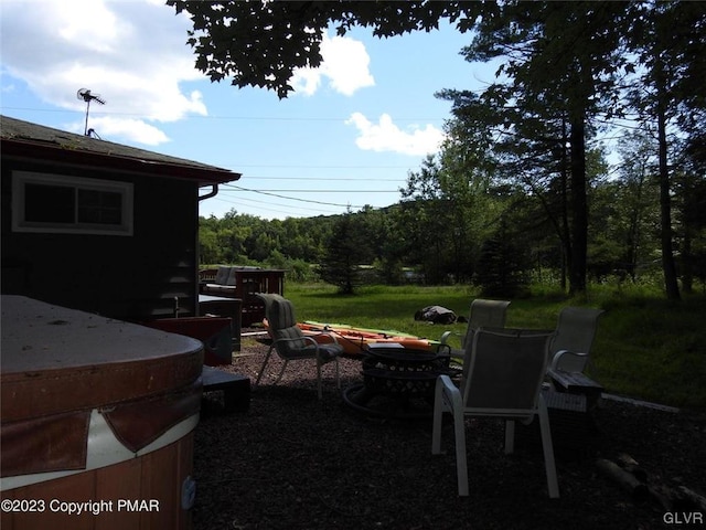 view of yard with a fire pit and a hot tub