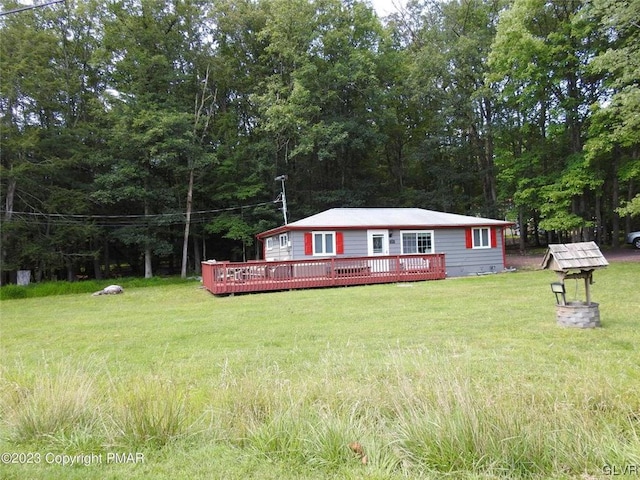 view of front facade featuring a wooden deck and a front yard