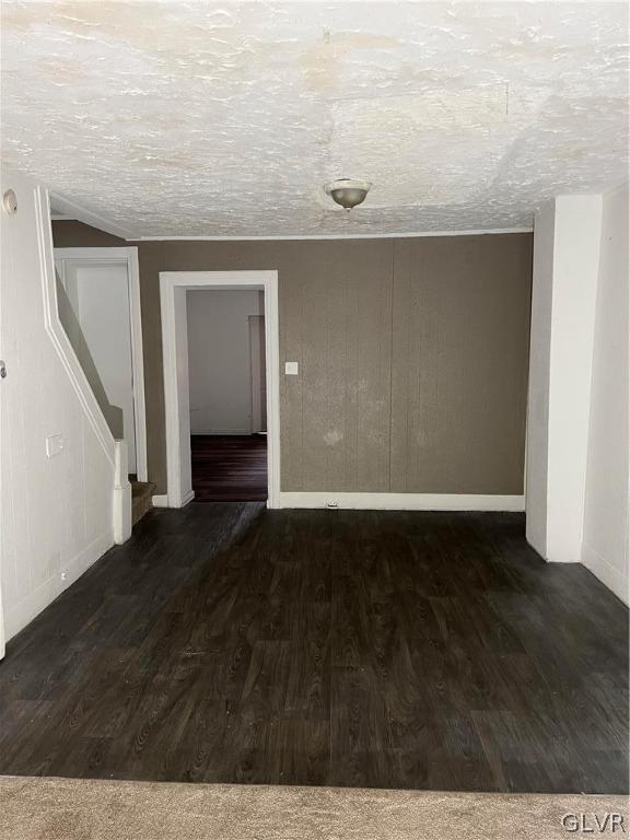 spare room with a textured ceiling and dark wood-type flooring